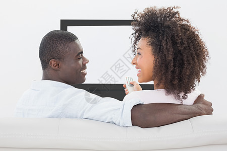 坐在沙发上看电视的一对夫妇遥控公寓房子长椅频道夫妻男性感情闲暇享受图片