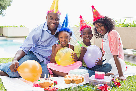 一家人一起在花园庆祝生日 幸福的家童年派对男生男性闲暇团结气球蛋糕展示礼物图片