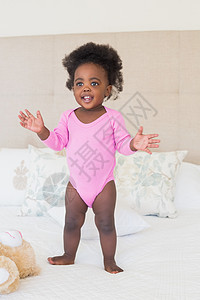 穿粉红婴儿裤的小女孩宝宝 站在床上服装棉被女性羽绒被用品玩具玩具熊女孩新生活粉色图片