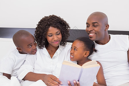一起在床上看家庭阅读书快乐男性女孩学习文学卧室儿子母亲父亲女儿混血图片