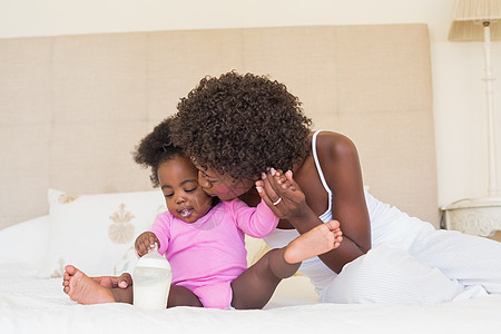 父母在床上带着女婴的快乐女性棉被家庭生活羽绒被女士感情幸福家庭婴儿房子图片