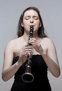 青年女音乐家扮演Clarinet工作室演员乐器玩家女孩音乐女性钥匙女士音乐家图片