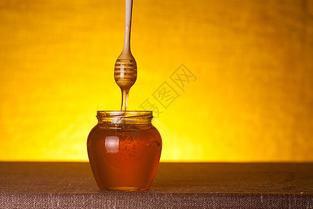 蜂蜜罐 配有木制花瓶和流动蜂蜜图片