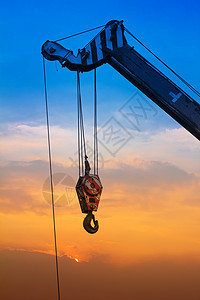 日落时起重机蓝色天空绳索商业建筑工程金属建筑学吊装手臂图片