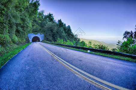 清晨在蓝脊坡道上穿过山丘的隧道旅行环境乡村运输海拔大路管子地质学硬木假期图片