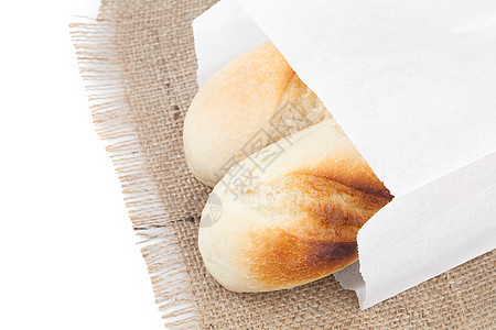 面包包装在一个纸袋里 在白色上被隔开工作室饮食脆皮谷物市场金子美食厨房食物店铺图片