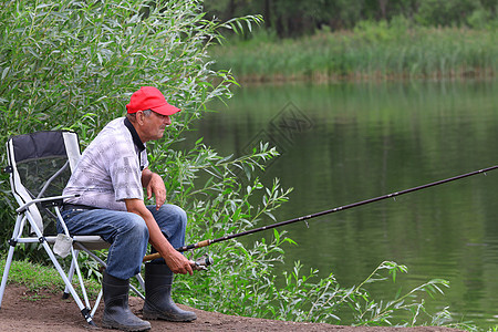 河里有渔夫鱼 中年人享受设施椅子爱好帽子晴天运动卷轴成人铸件图片