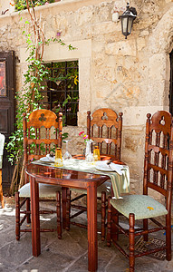 Greek 咖啡厅的表格设置座位椅子午餐阳光街道盘子露天家具桌子咖啡店图片
