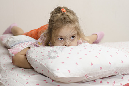 女孩躺在床上 把脸藏在枕头里图片