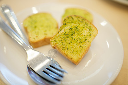 大蒜和香草面包勺子硬皮白色食物草本植物香菜黄油盘子图片