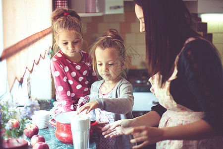 母亲和孩子在厨房女儿们烹饪食物父母女孩们童年生活家庭孩子们房子图片