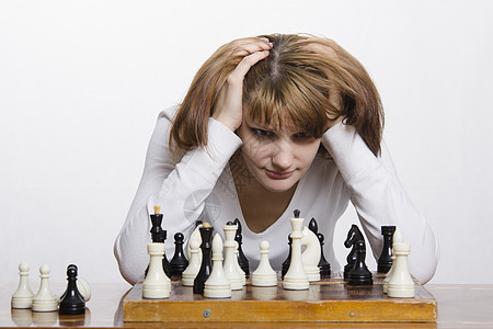 年轻女孩在象棋游戏虑一招的举动头脑乐趣戏剧逻辑数字运动图片