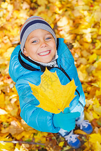 有秋叶的可爱男孩叶子公园男生孩子夹克幸福季节帽子乐趣童年图片