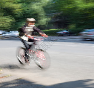 在城市公路上交通中骑自行车的男孩踏板运动运输骑士男人汽车头盔街道速度生态图片