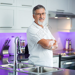高级男子站在他翻新的现代厨房里图片