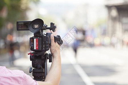 用摄像机拍摄一个活动广播全球通讯新闻业技术街道报告文学居住操作员视频图片