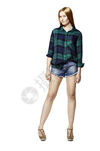 有吸引力的年轻女性短裤绿色衬衫牛仔裤蓝色影棚女孩金发女郎头发图片