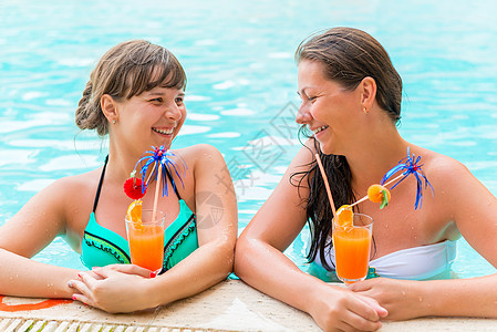 两个朋友在游泳池里笑着开玩笑图片