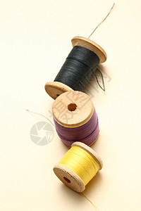 3个线串封结的bobbins棉布纺织品针织缝纫工具黑色木头圆柱主轴卷轴图片