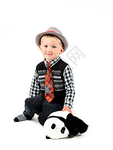 带着玩具微笑的快乐男孩 在工作室拍摄一个白色的背黑锅图片
