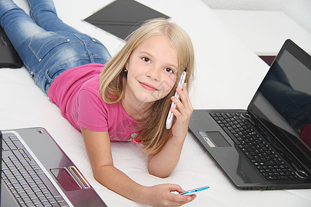 在家里用平板 笔记本电脑和电话玩游戏的小孩乐趣快乐软垫学习互联网技术儿童女孩们童年沙发图片