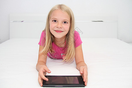 在家里用平板 笔记本电脑和电话玩游戏的小孩幸福互联网沙发教育学习白色药片童年技术乐趣图片