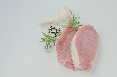 配有迷迭香和大蒜的生猪排草药营养火腿饮食猪肉厨房食物木头美食斧头图片