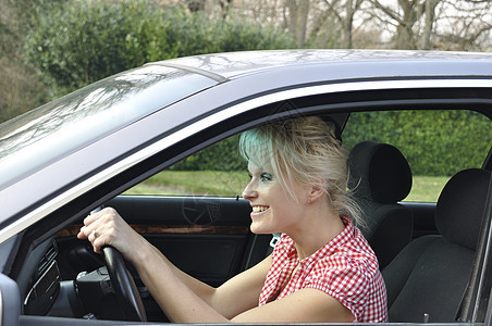 妇女驾驶一辆灰色汽车成人旅行发动机运输乐趣青年车辆安全女性司机背景图片