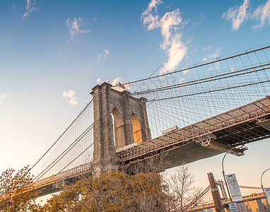 从布鲁克林街道上看到的日落时的布鲁克林桥内景观建筑学天空天际公园旅行风景出租车地标黄色图片