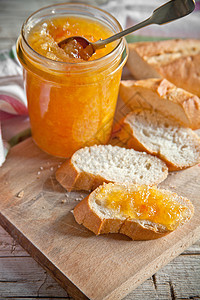 橙色果酱在玻璃罐子和面包养护美食早餐小吃餐巾小麦产品传播装罐浆果图片