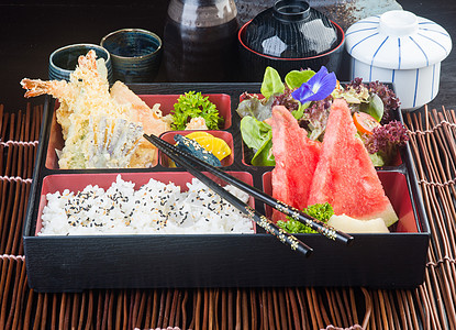 日式美食 午餐盒套在背景上水果黄瓜土豆叶子油炸海鲜小烧寿司美味猪肉图片