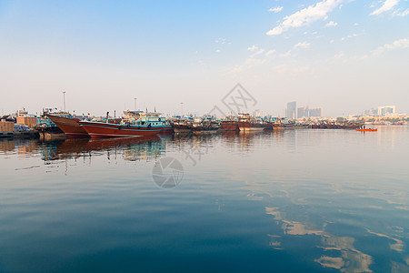 现代城市中大型木制船只的码头蓝色运输帆船渡船贸易旅行海湾血管天空航行图片