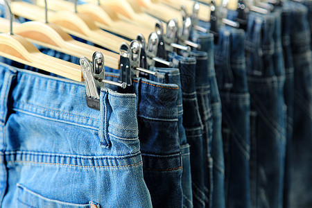 紧贴蓝色牛仔裤壁橱架子裤子服装商业材料裙子服饰衣柜织物图片