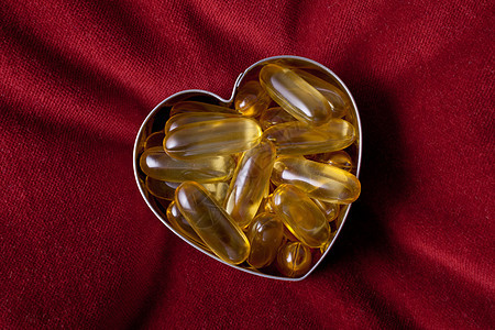 以心脏形状排列的维他命胶囊金属甜点药店医疗床单白色宏观药品传统图片