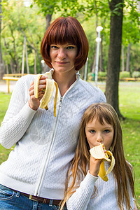 母亲和女儿吃香蕉女士女学生家庭白色父母童年女性孩子背景图片