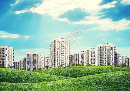 绿色山上高楼建筑蓝色房地产天空射线城市草地场地灰色地面居住图片
