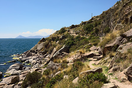 玻利维亚Copacabana附近的Titicaca湖的落基海岸线踪迹擦洗海岸晴天支撑石头岩石吸引力游客人行道图片