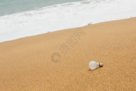 沙滩上的旧灯泡白色垃圾回收尘土力量生态烧伤玻璃环境图片
