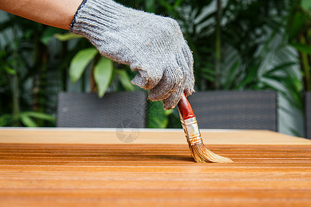 在木制桌子上用手笔刷笔和绘画座位家具椅子长椅公园红色男人木头木匠花园图片