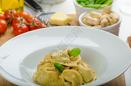 装满菠菜和大蒜的自制托塔利尼厨房食物生物营养桌子烹饪美食坚果糖类香菜图片