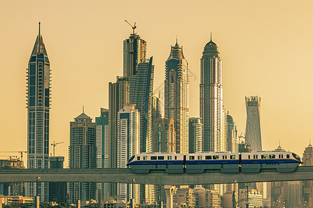 迪拜日落时有地铁和摩天大楼图片