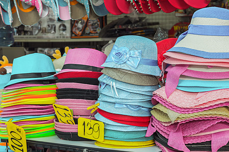 供出售的多彩色夏季帽子衣服女性服装太阳纺织品店铺晴天收藏魅力销售图片