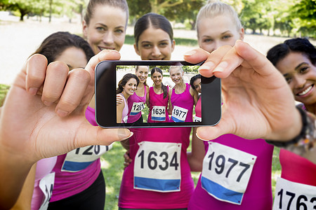 手持智能手机显示的复合图象技术参加者公园女性女士体育活动数字屏幕绿地图片