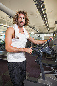 男子在健身房站着运动自行车图片