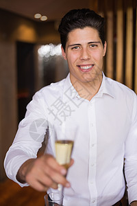 帅哥笑着拿着香槟的摄影机混血气泡男人服务玻璃裙子夜店奢华微笑男性图片