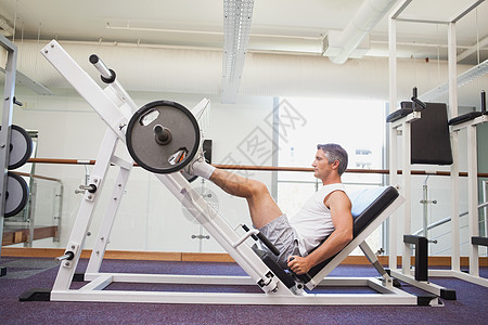 用双腿举起重巴铃的合适男子调理肌肉专注运动服训练男人杠铃健身大男子健身室图片