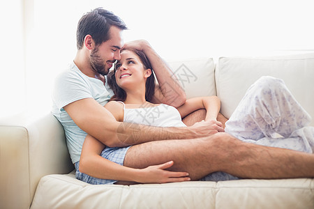 情侣在沙发上放松闲暇客厅女朋友拥抱男朋友快乐说谎女性家庭生活感情图片