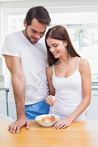 年轻夫妇吃健康早餐的年青夫妇微笑厨房男性快乐女士夫妻家庭生活水果沙拉房子图片