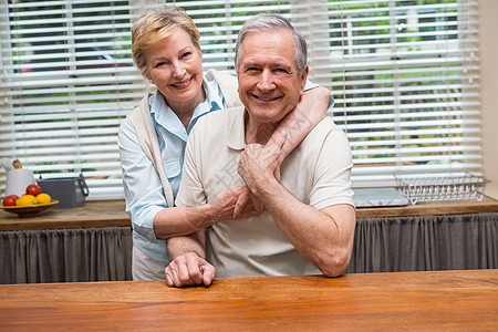 老夫妇在镜头前笑着微笑在一起房子闲暇厨房老年柜台夫妻拥抱男人公寓住所图片