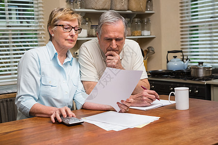年长夫妇共同解决他们的帐单老年人闲暇婚姻会计写作男人女士收据专注房子图片